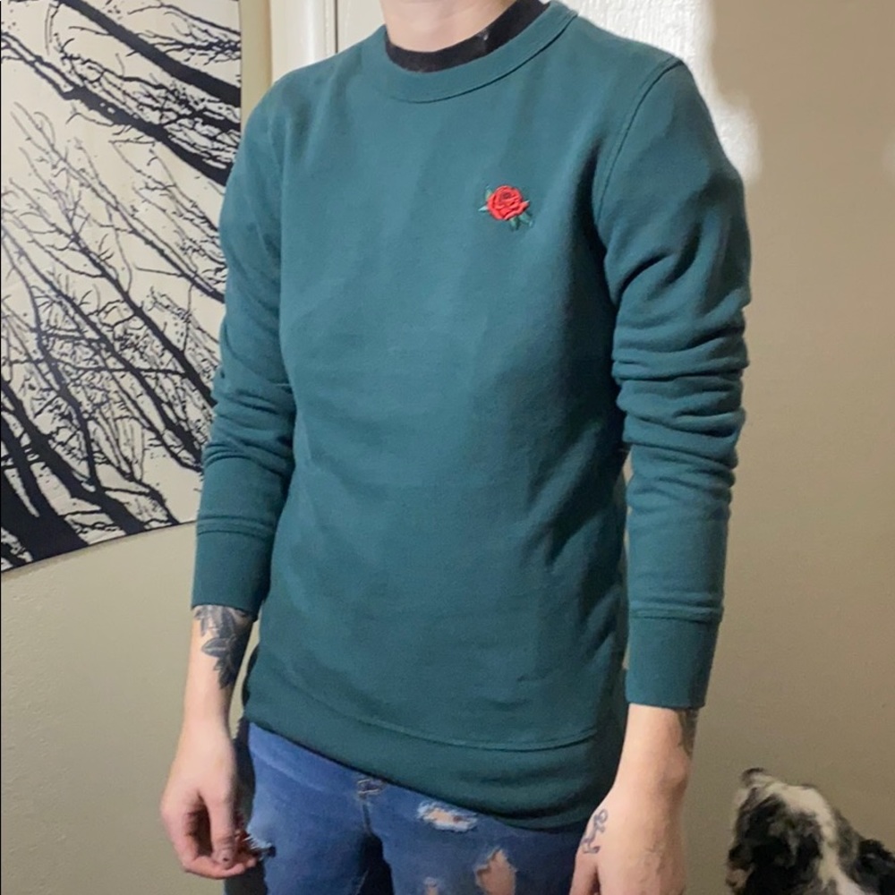 Green sweater with rose emblem